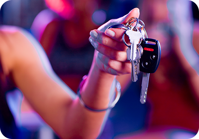 Photo of an arm handing car keys to someone presumably in a night club or bar setting