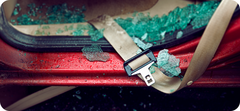 Photo of unbuckled seat belt in shattered vehicle window